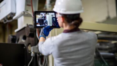 a worker performs a preventative maintenance inspection with a tablet