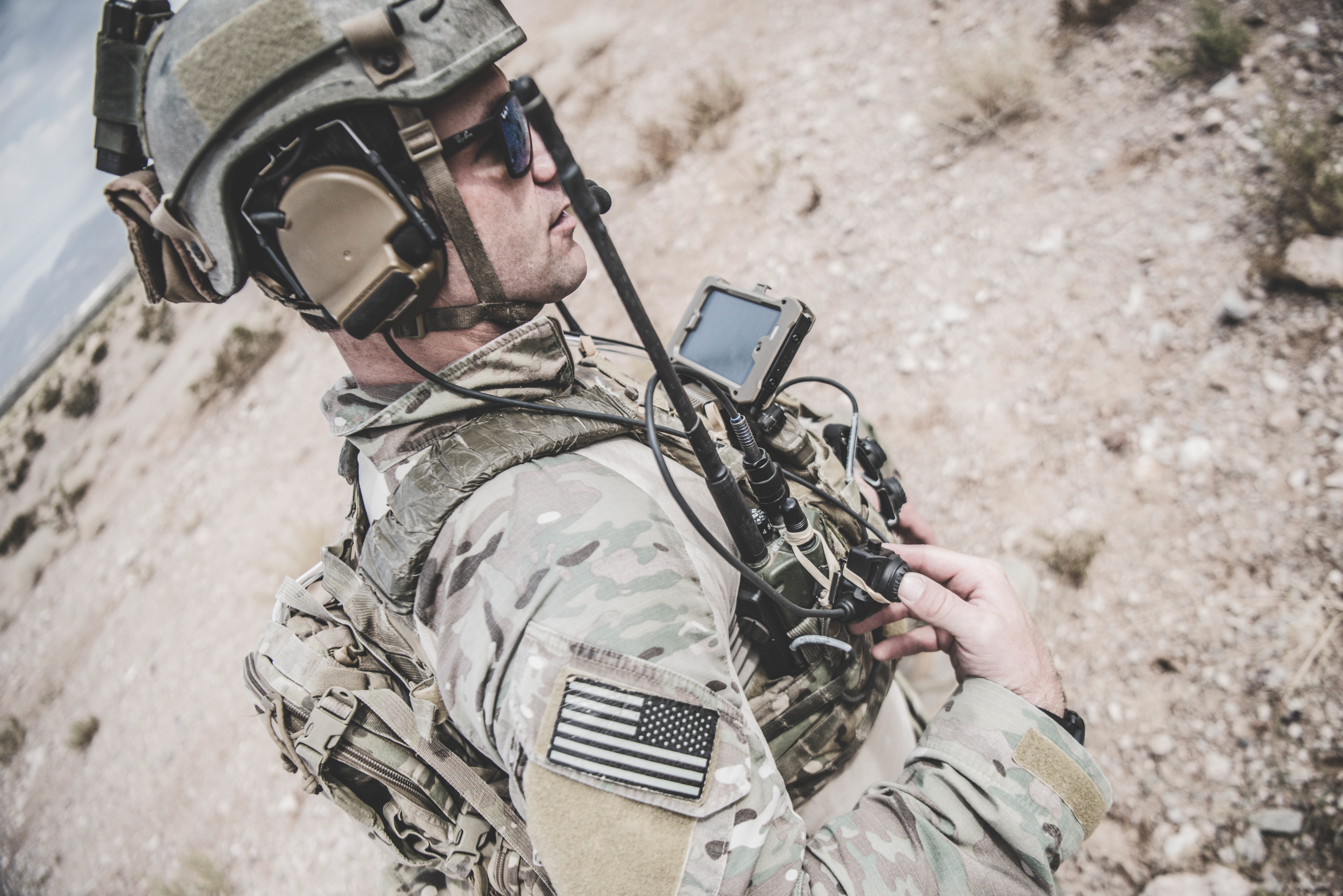 A U.S. soldier in tactical gear uses a Samsung Galaxy Tactical Edition in the desert