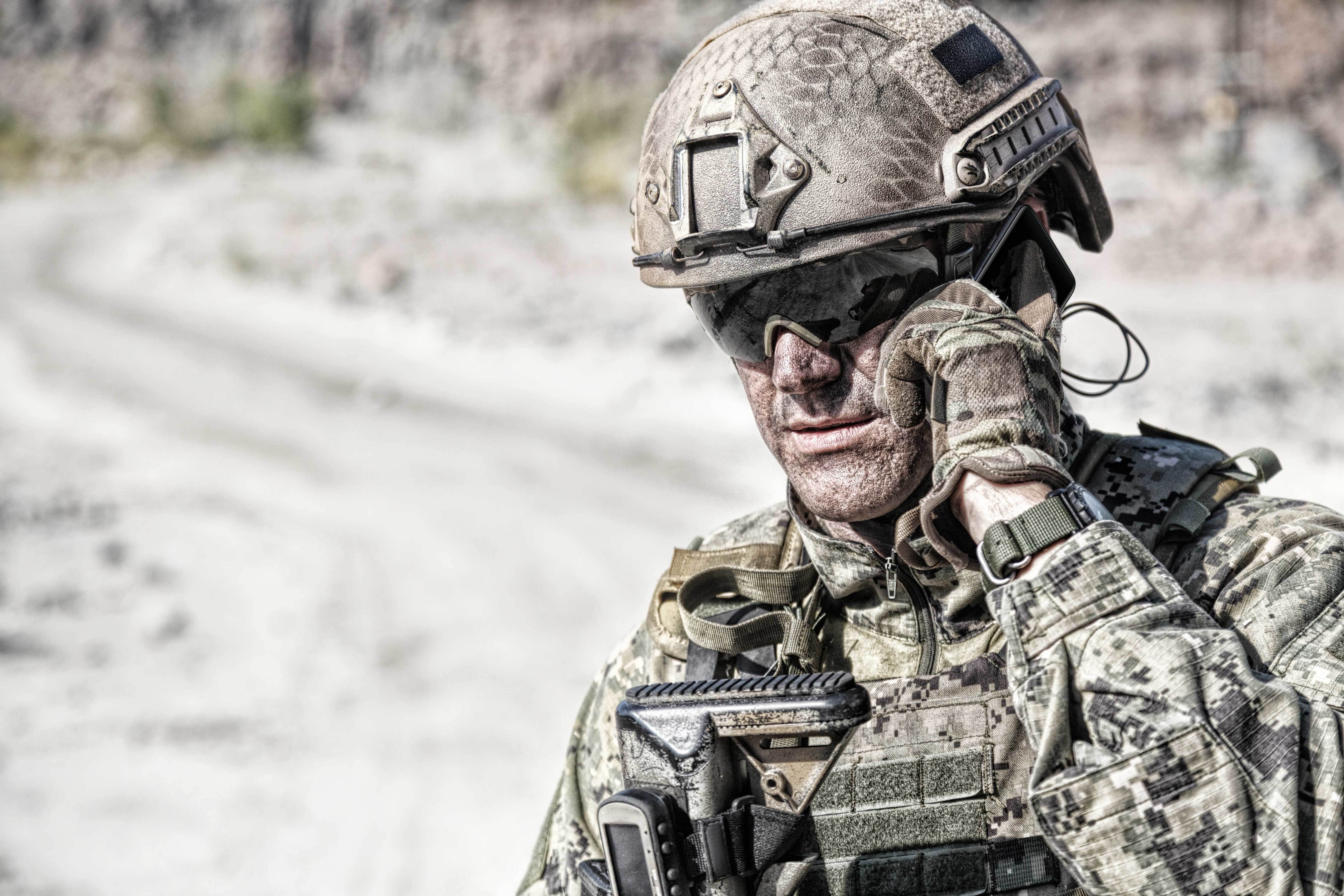 A U.S. soldier in tactical gear uses a Samsung Galaxy Tactical Edition in the field