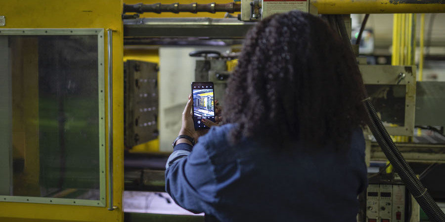 A manufacturing worker uses a Samsung Galaxy XCover Pro on the job