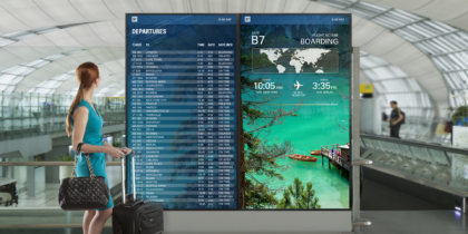 A digital display in an airport shows travelers their flight information