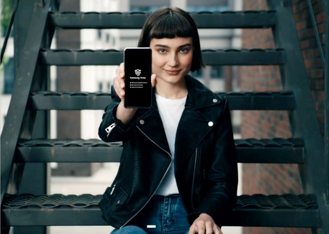 Woman holding Samsung smartphone with Knox logo on screen