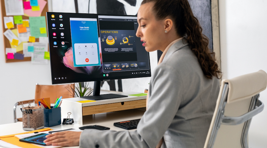 Businesswoman using her Galaxy Z Fold3 connected to a Smart Monitor in DeX mode