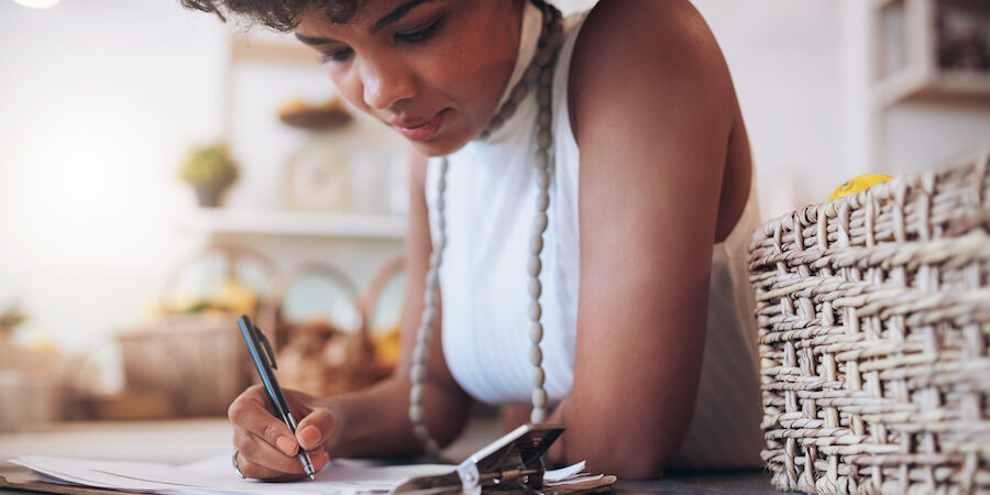 Young business owner doing paperwork at countertop.