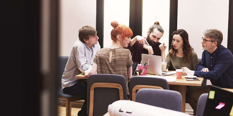 Business employees collaborating around conference table