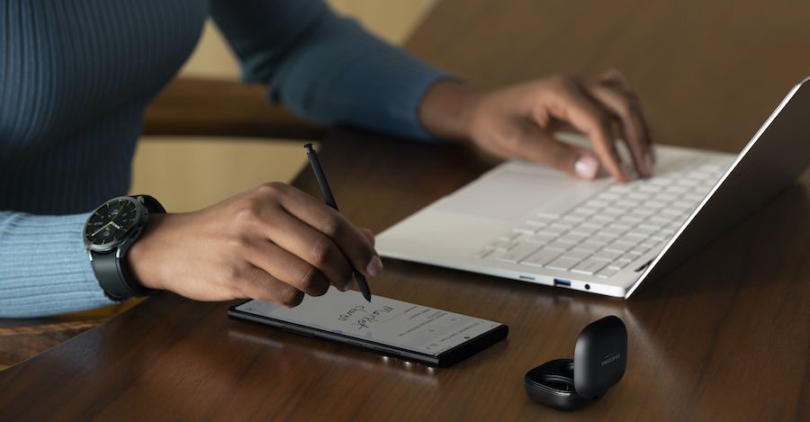 Small business employee working at desk on laptop and smartphone