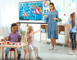 In an elementary school classroom, a teacher leads a science lesson on an interactive whiteboard.