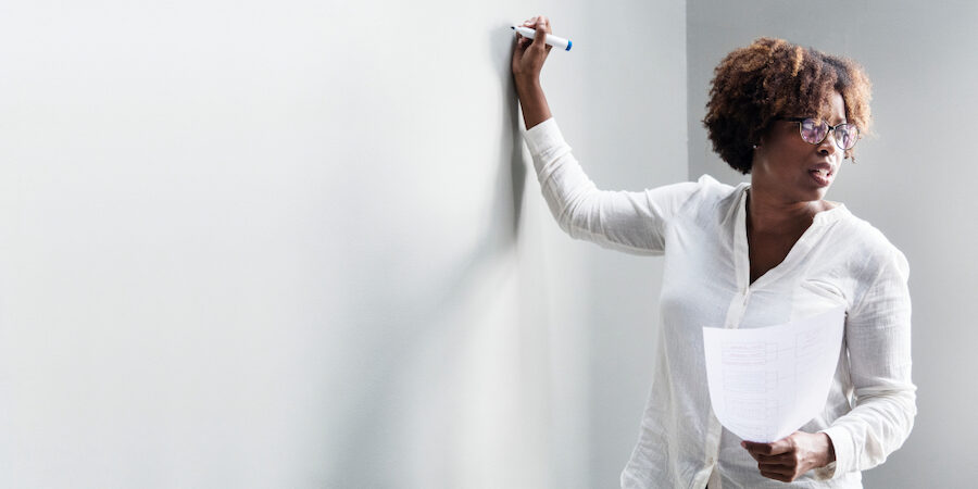 Black woman writing on a whiteboard