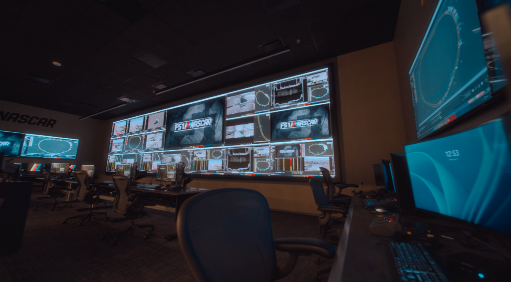 A wide view of the NASCAR Productions Remote Race Control Room in Concord, North Carolina, featuring Samsung’s massive "The Wall" microLED display split into dozens of live racing video feeds, data streams, and track maps.